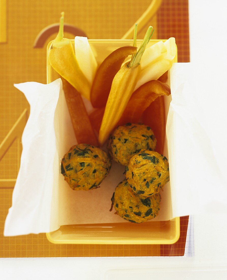 Carrot falafel with vegetables in a plastic box