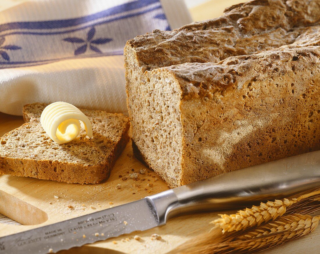 Sourdough rye bread, partly sliced with butter