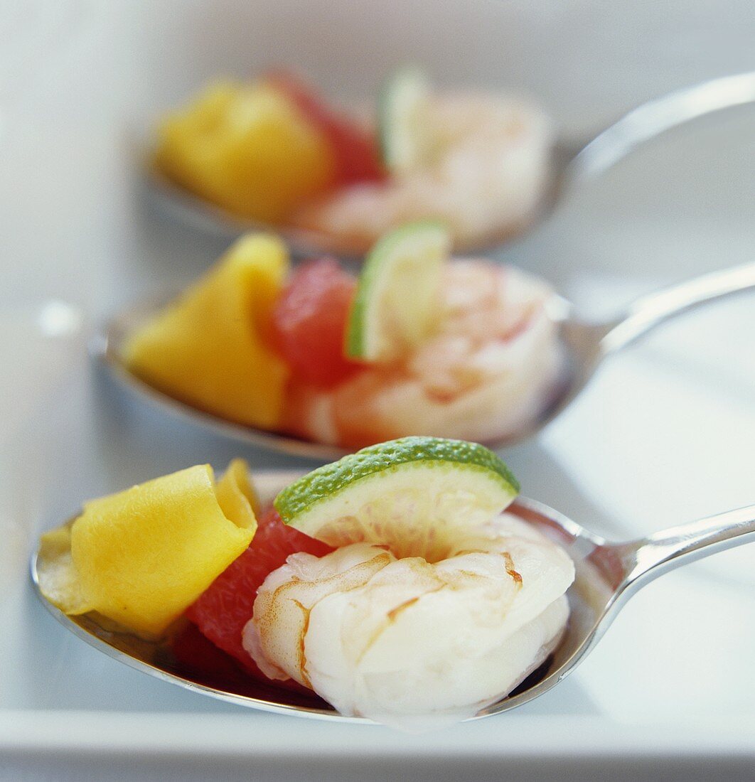 Prawns with lime, grapefruit and mango on spoons