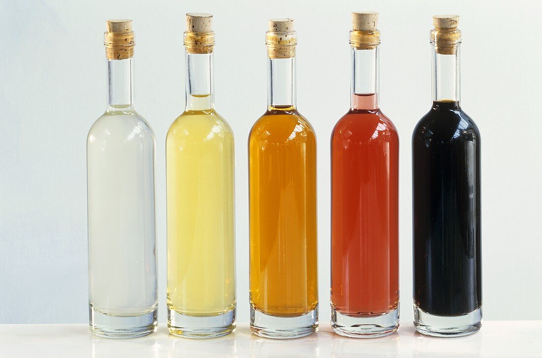 Fünf verschiedene Essigsorten in Flaschen