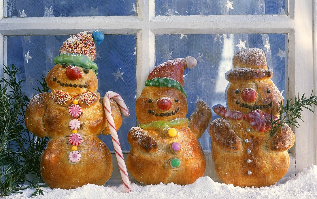 Baked snowmen (yeast dough) in front of a window