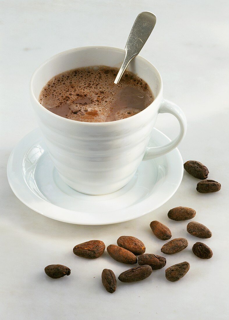 A cup of cocoa with cocoa beans
