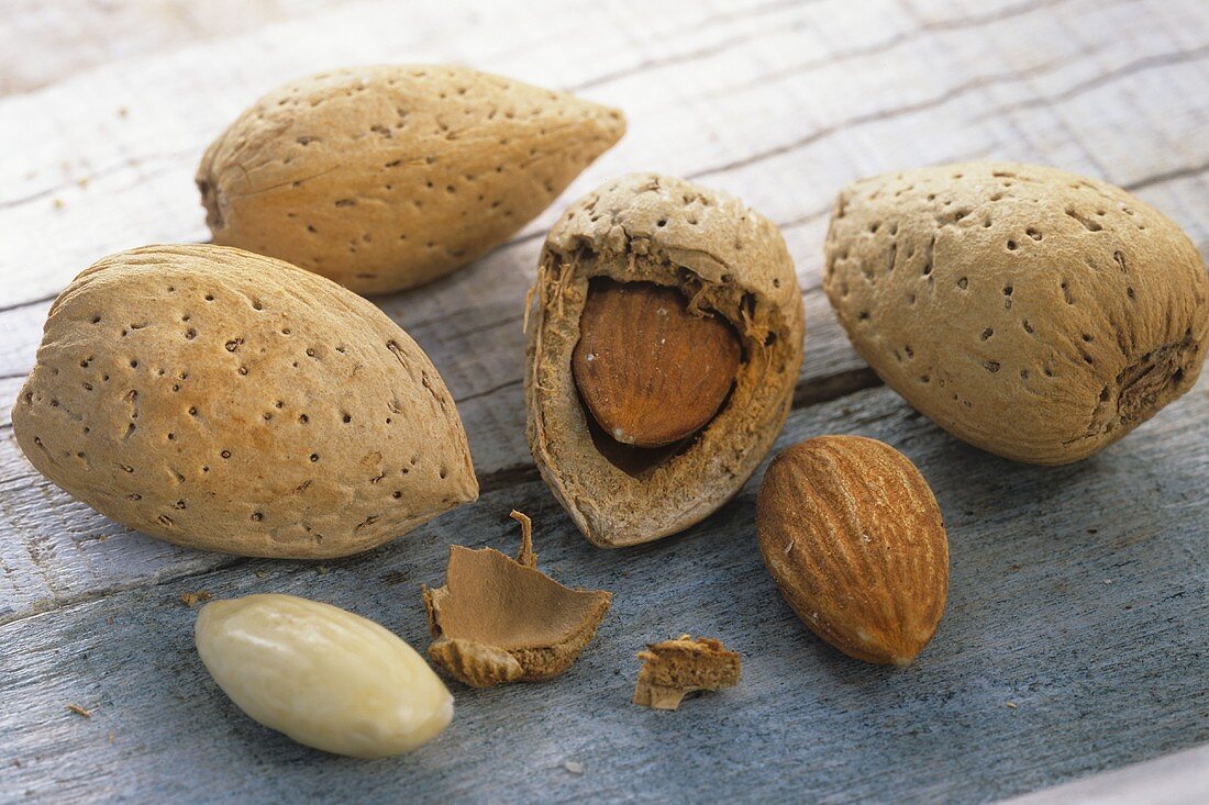 Shelled and unshelled almonds on wooden background