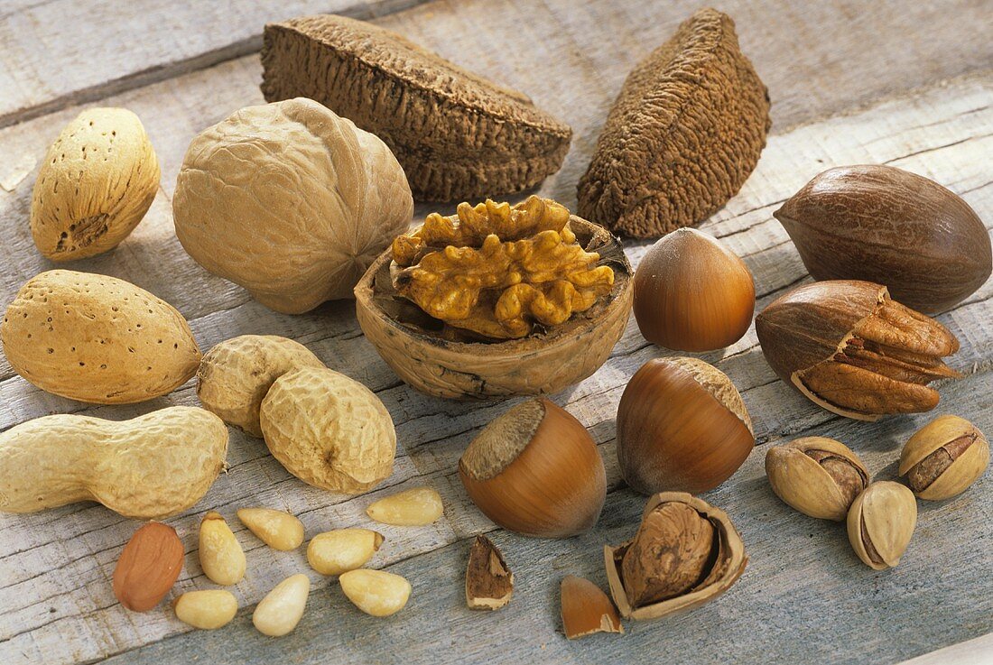 Assorted nuts, shelled and unshelled, on wooden background