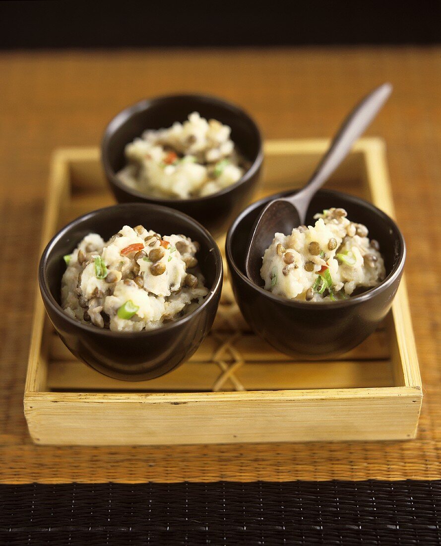 Three small bowls of mashed potato with lentils