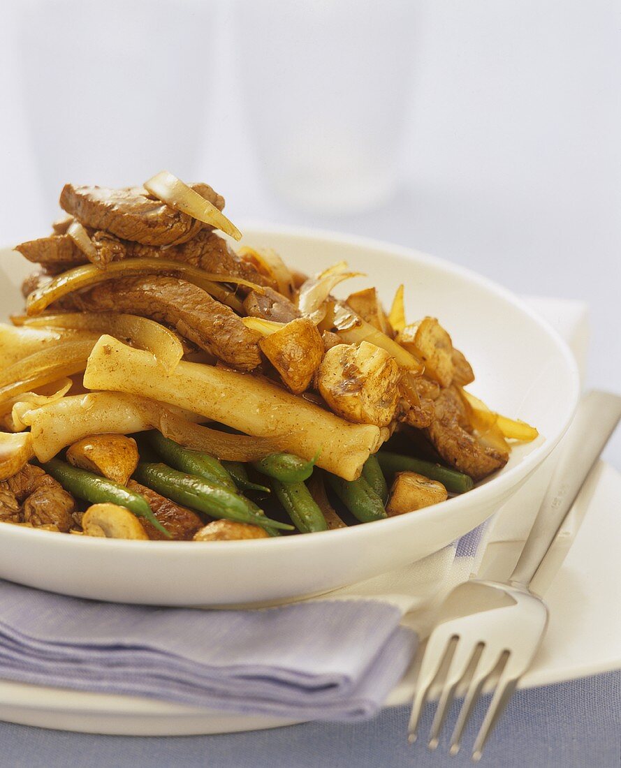 Gebratenes Kalbfleisch mit Bohnen, Champignons und Nudeln