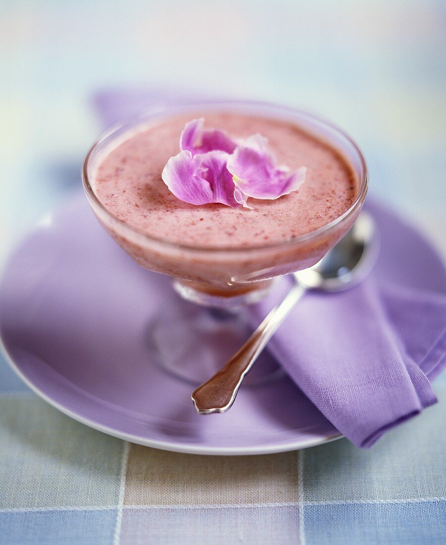 Strawberry cream with flower petals in dessert glass