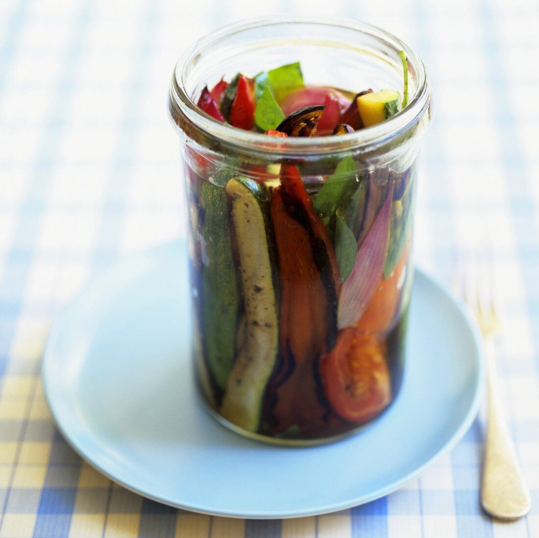 Mediterranean vegetables with basil in olive oil in jar