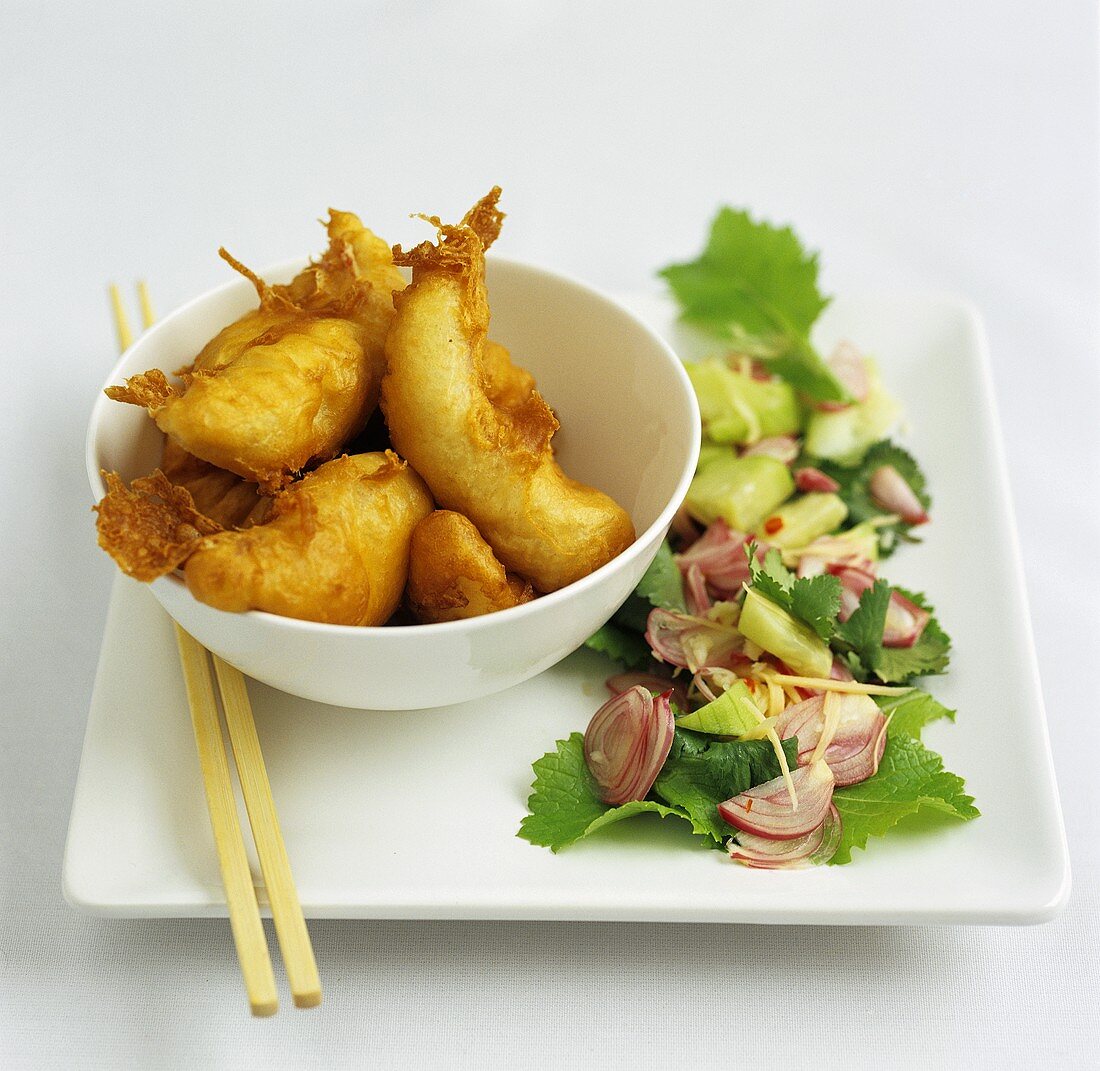 Fried fish in batter with cucumber and shallot salad