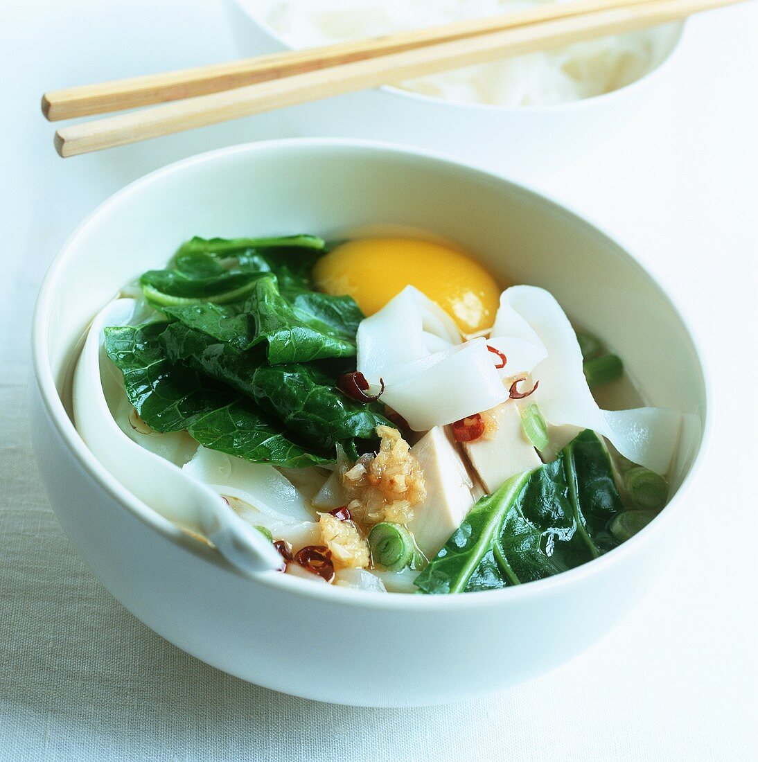 Soup with rice noodles, pak choi, egg, tofu and chilli