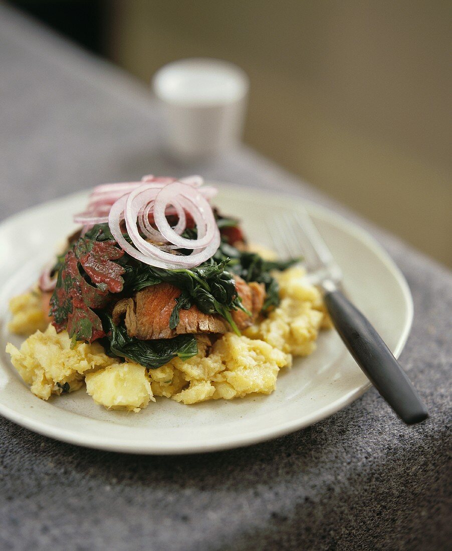 Steak with spinach on a bed of potatoes