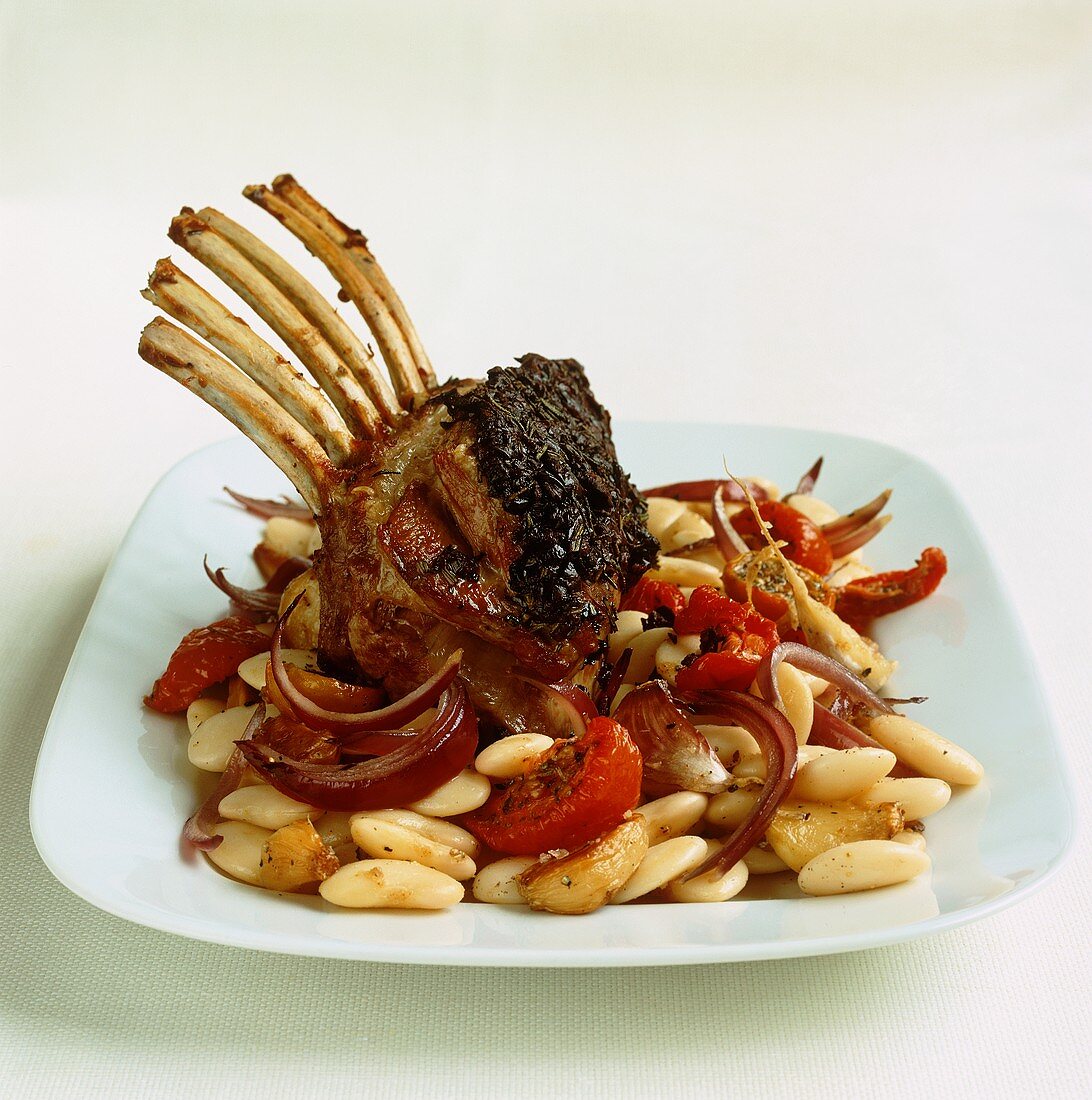 Saddle of lamb with an olive and rosemary crust on beans and vegetables