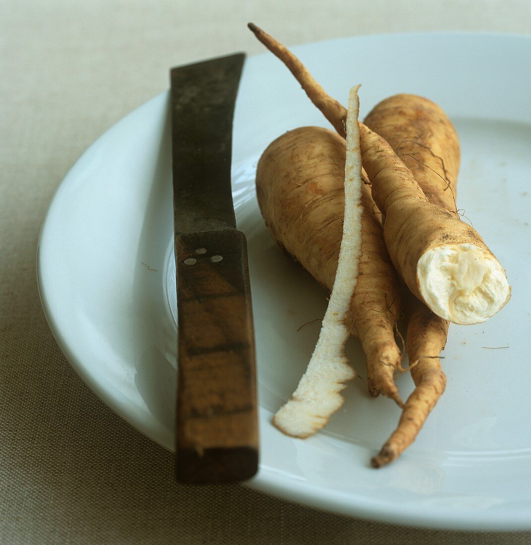 Parsnips on a plate with a knife