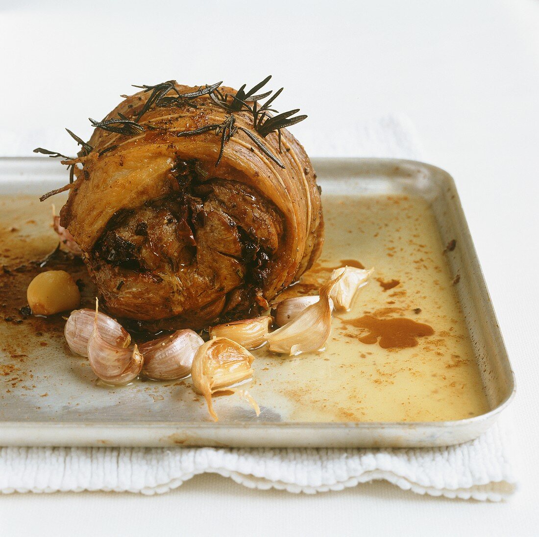 Pork roulade with garlic on a baking tray