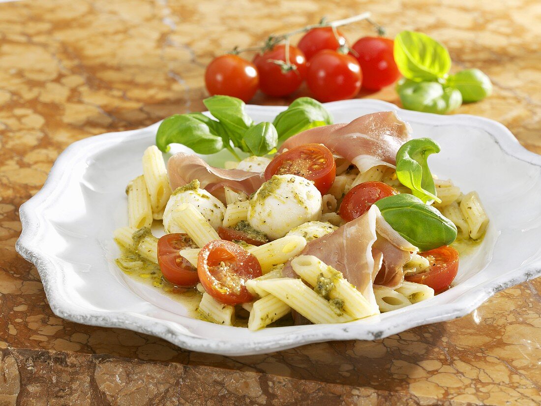 Pasta salad with mozzarella, tomatoes, pesto and Parma ham