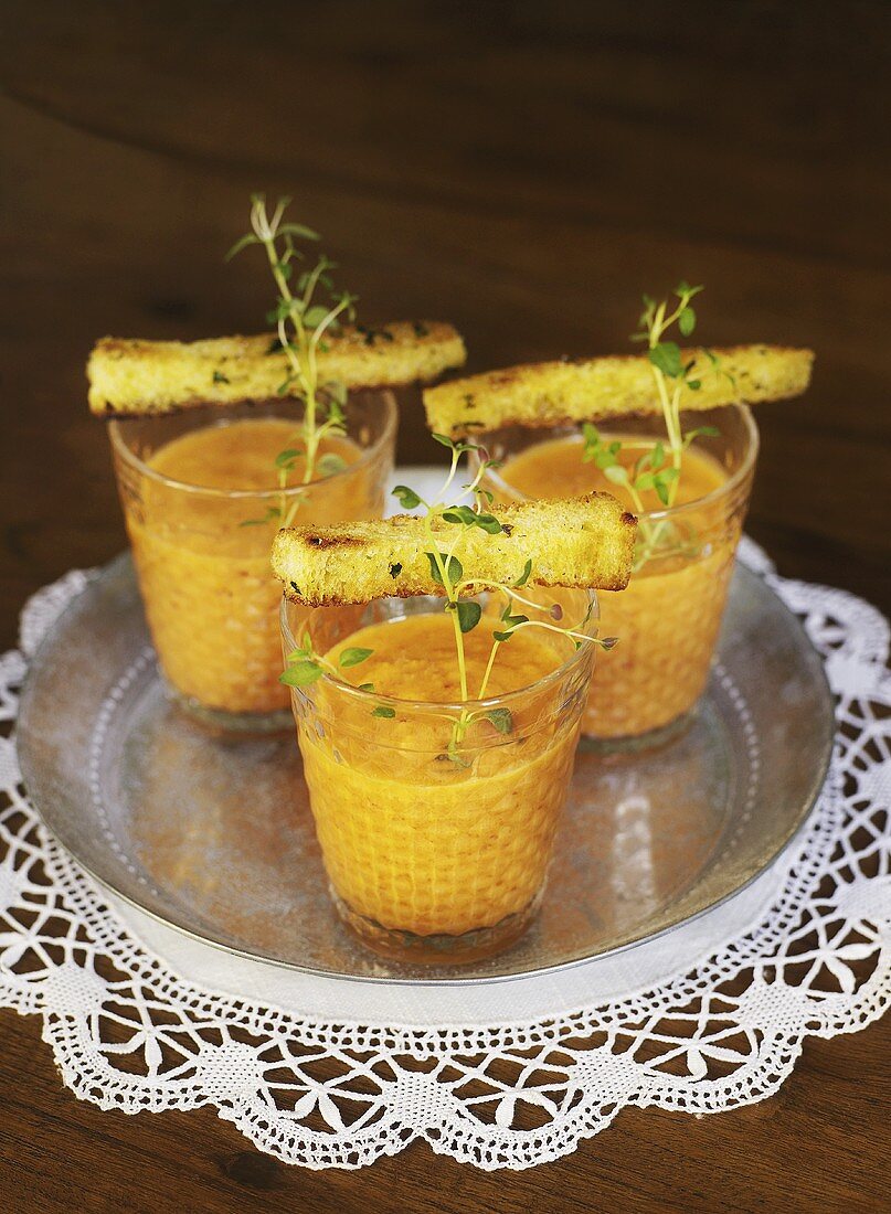 Three glasses of gazpacho with cress and croutons