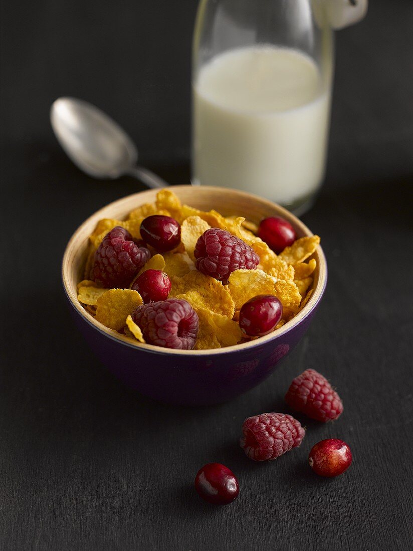 Cornflakes with berries and a bottle of milk