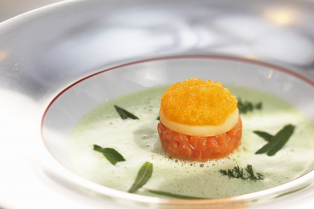 Wild herb soup with a layered canape made with potato, white fish tartar and caviar