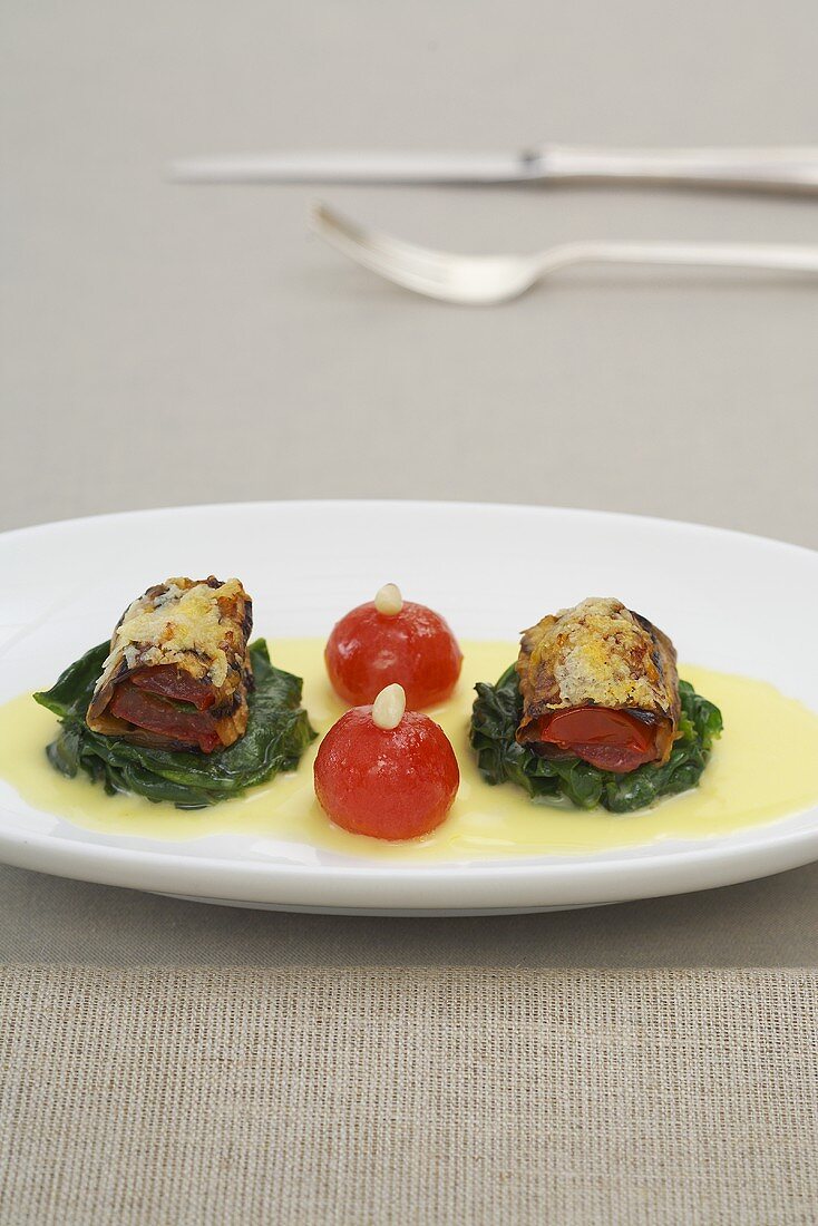 Aubergine roulade with tomatoes on spinach