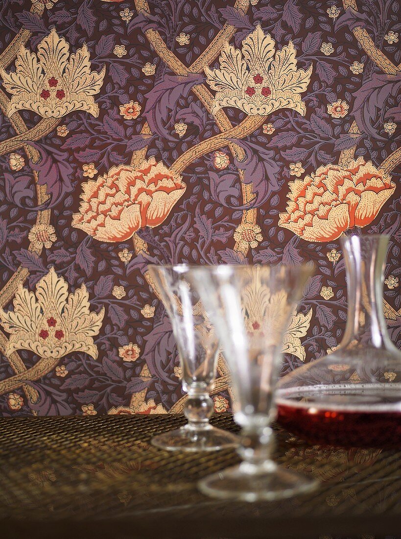 Wallpaper with a floral design and glasses with a carafe