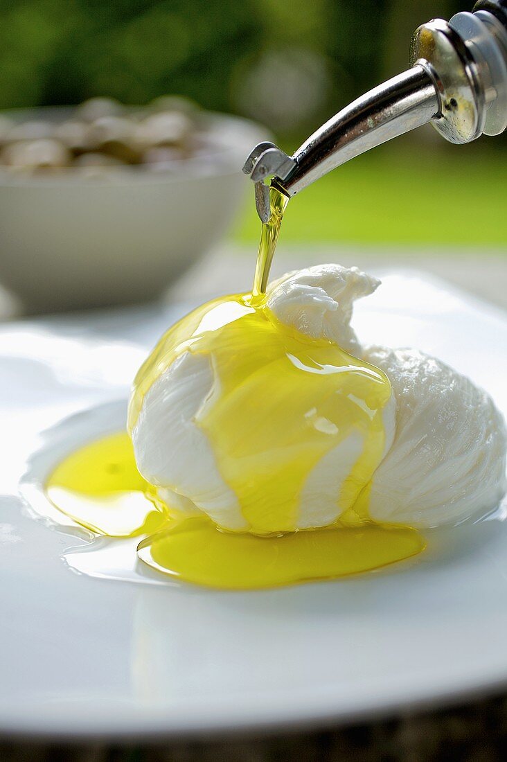 Mozzarella being drizzled with olive oil