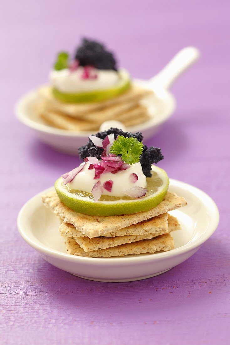 Cracker mit Sauerrahm, Limette, Zwiebel und Kaviar