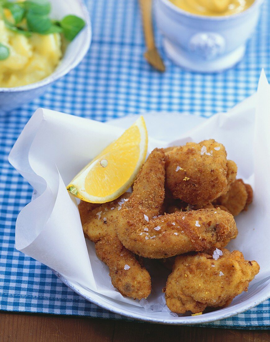 Bavarian fried chicken, potato salad and mustard behind