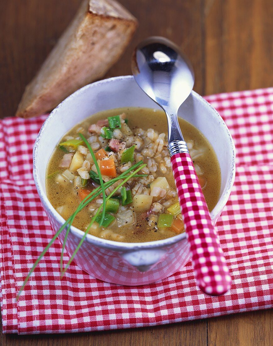 Hearty barley soup with vegetables and smoked bacon