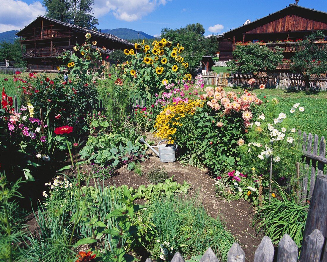 Kleiner Garten mit Blumen, Kräutern & Gemüse vor zwei Holz-Bauernhütte