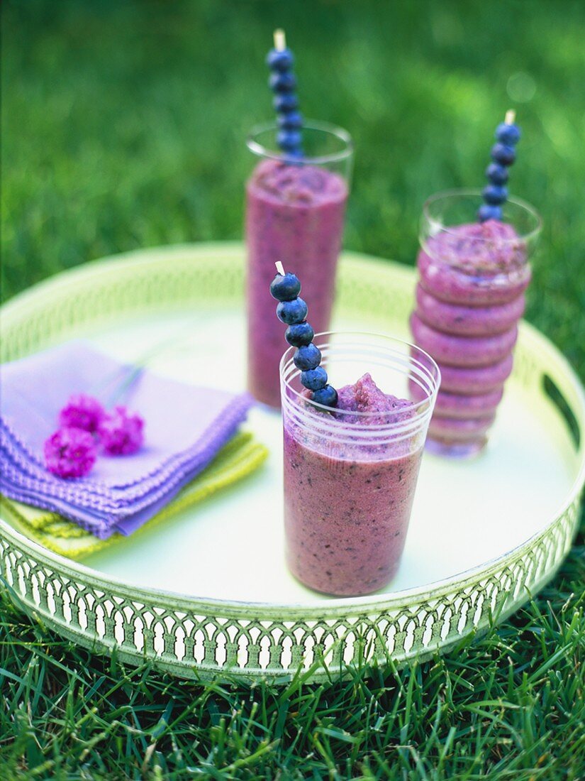 Three blueberry smoothies on a tray