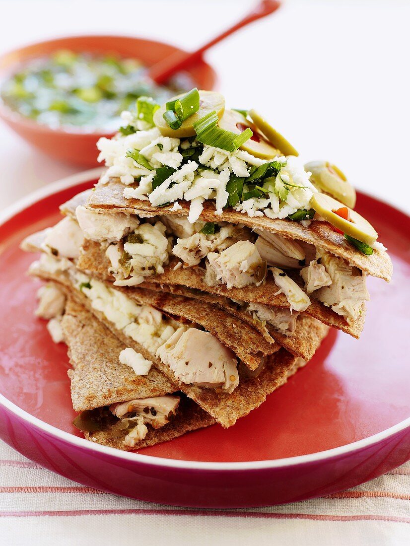 Tortillas with chicken, cheese, spring onions and olives