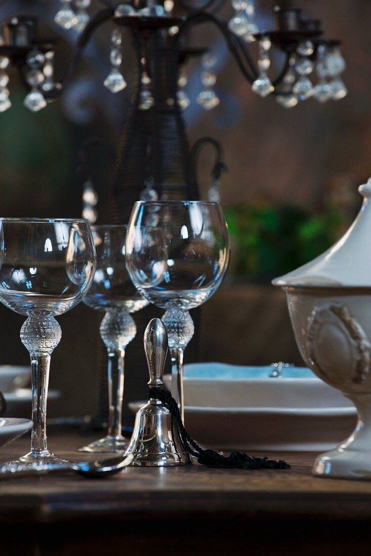 Empty wine glasses and table bell beside place-setting