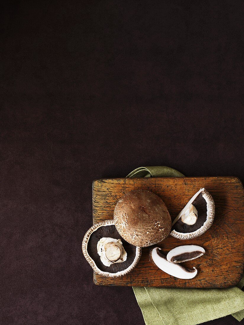 Portobello mushrooms on wooden board (overhead view)