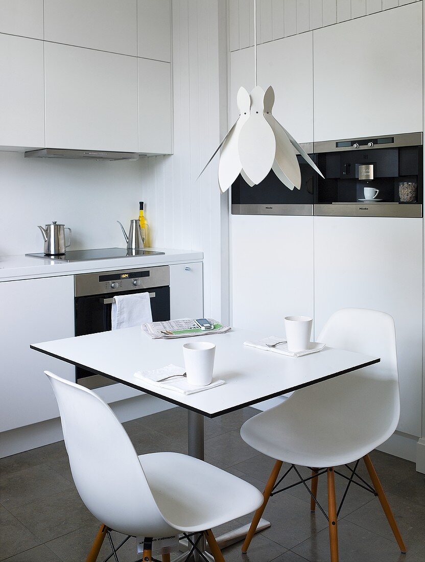 A kitchen with white table and chairs