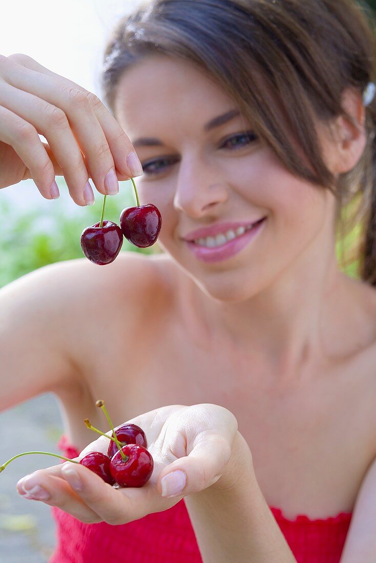 Young woman holding fresh cherries in her hands