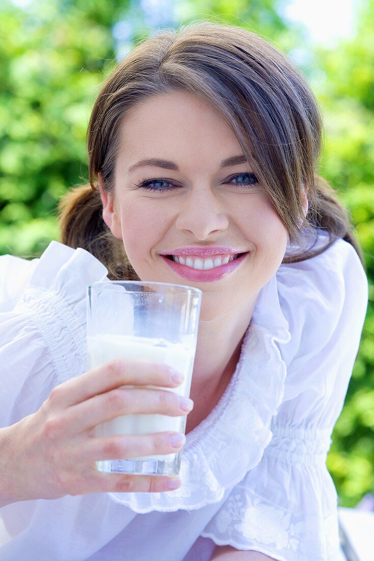 Junge Frau hält ein Glas Milch