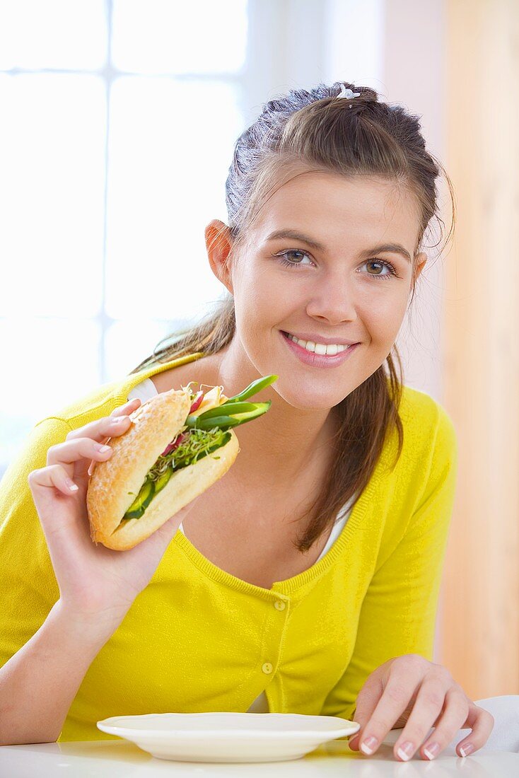 Girl eating vegetable sandwich