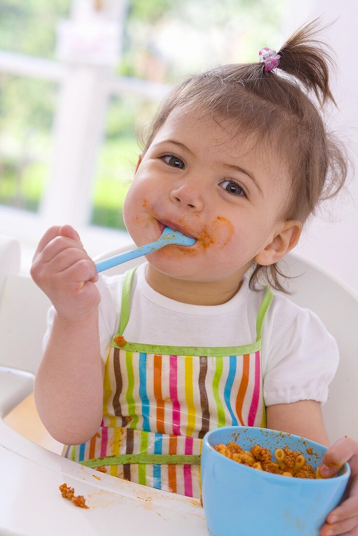 Mädchen isst Nudeln mit Sauce Bolognese
