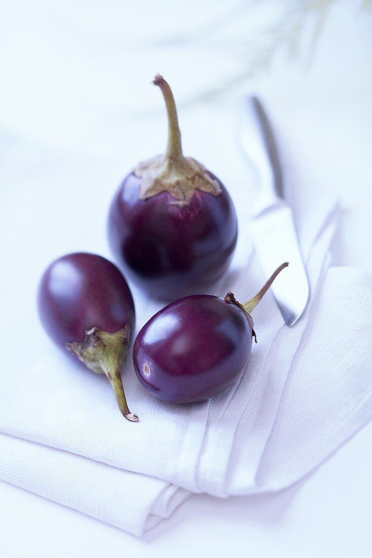 Aubergines on cloth with knife