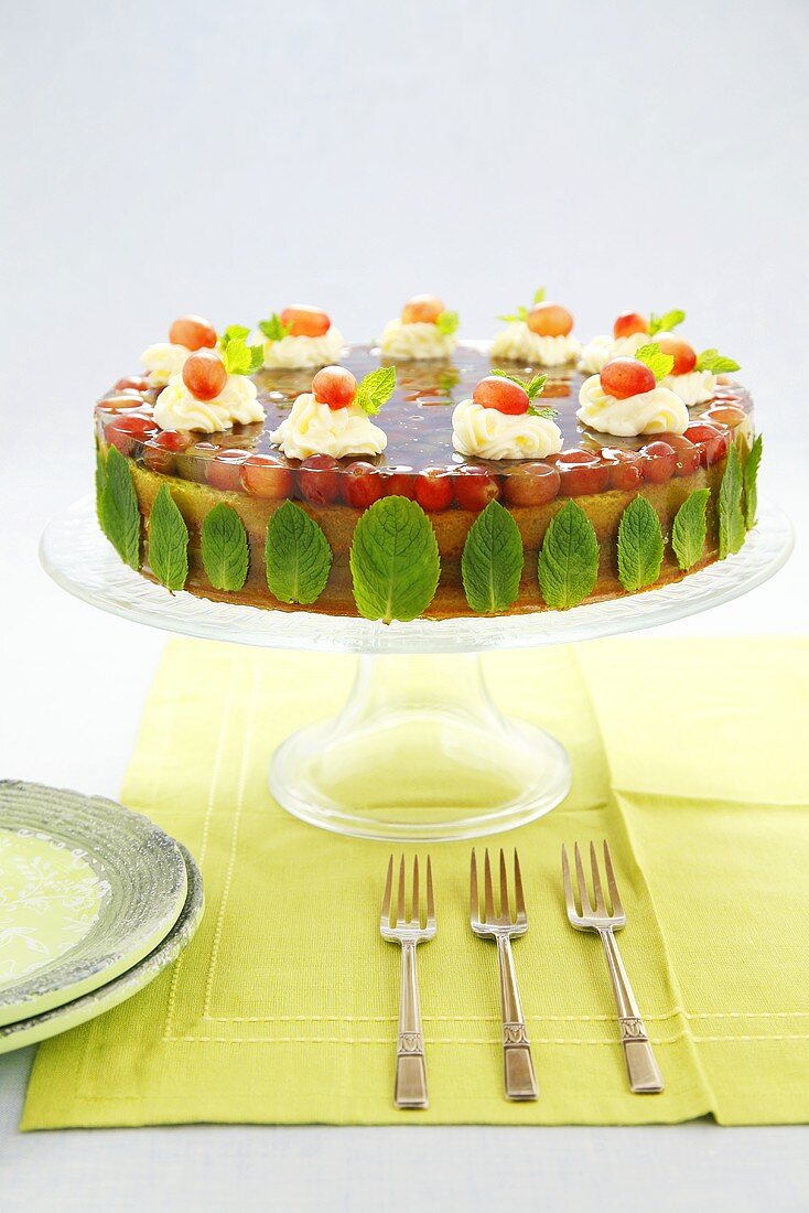 Cake with grape jelly, mint leaves and cream rosettes