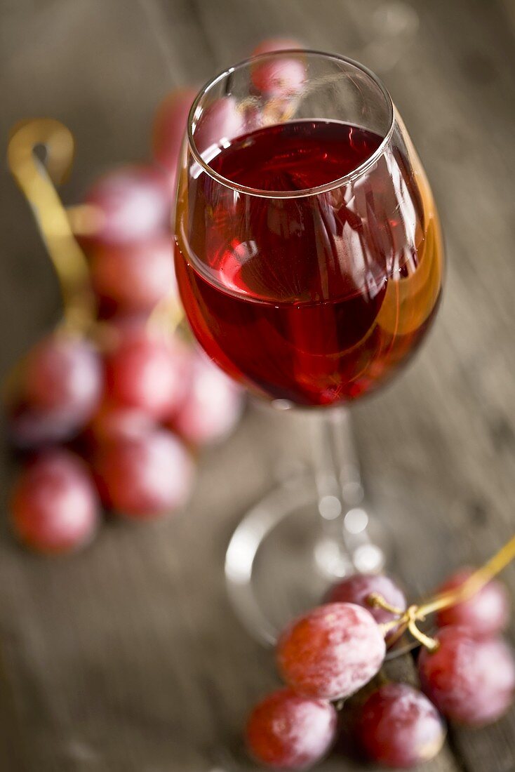 Glass of red wine and red grapes