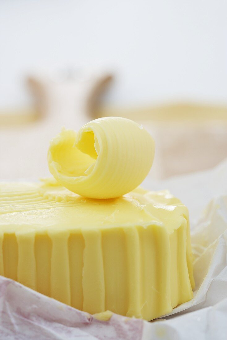 Butter curl on block of butter (close-up)