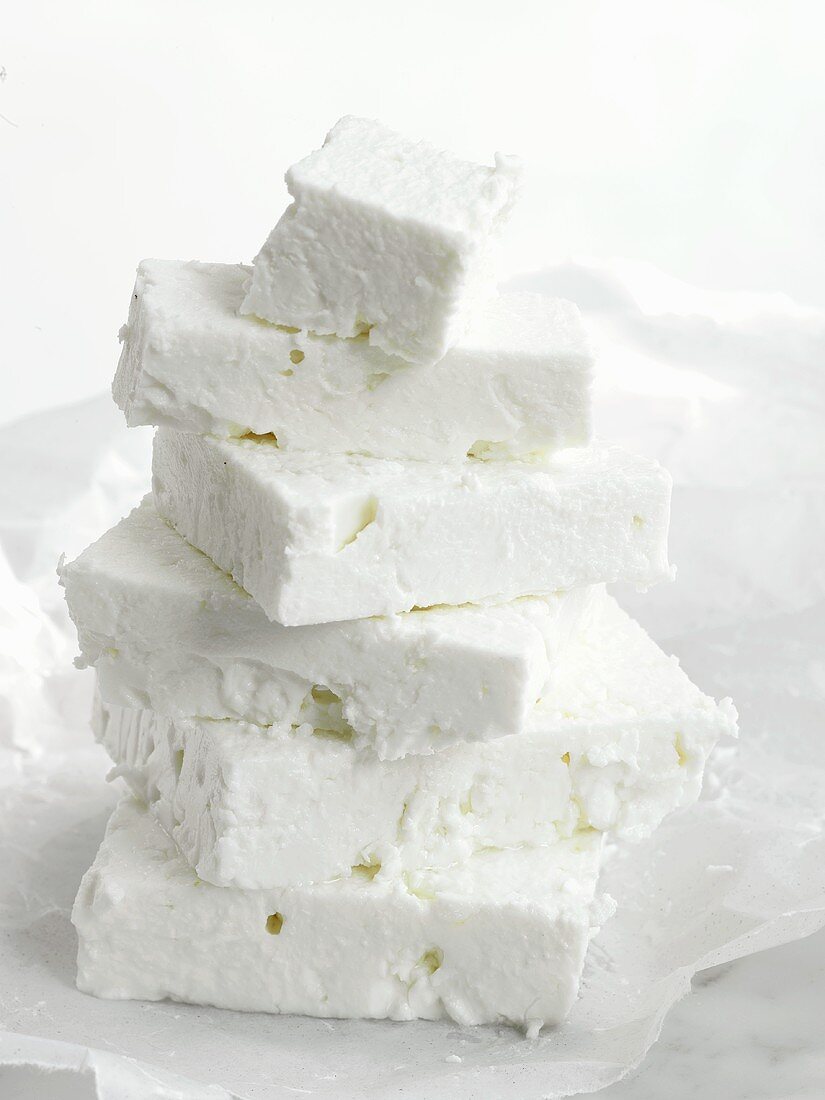 Pieces of feta cheese stacked on paper