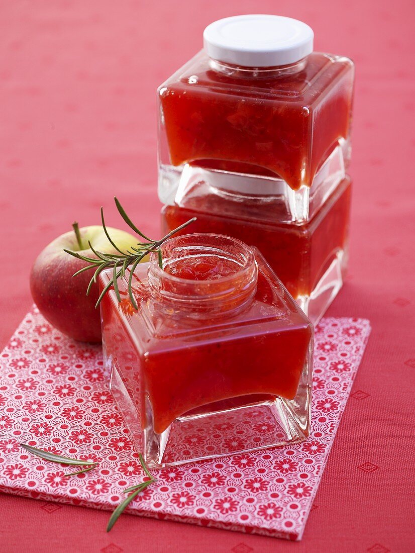 Several jars of strawberry and apple jam