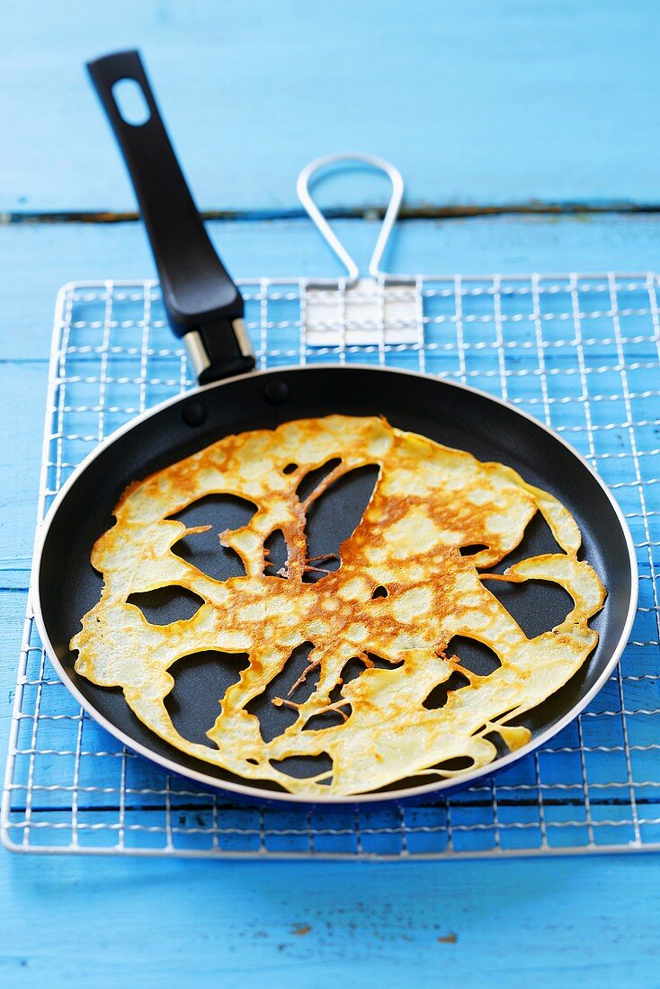 Holey pancake in frying pan