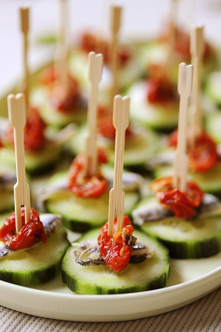 Appetisers: cucumber slices with dried tomatoes and anchovies