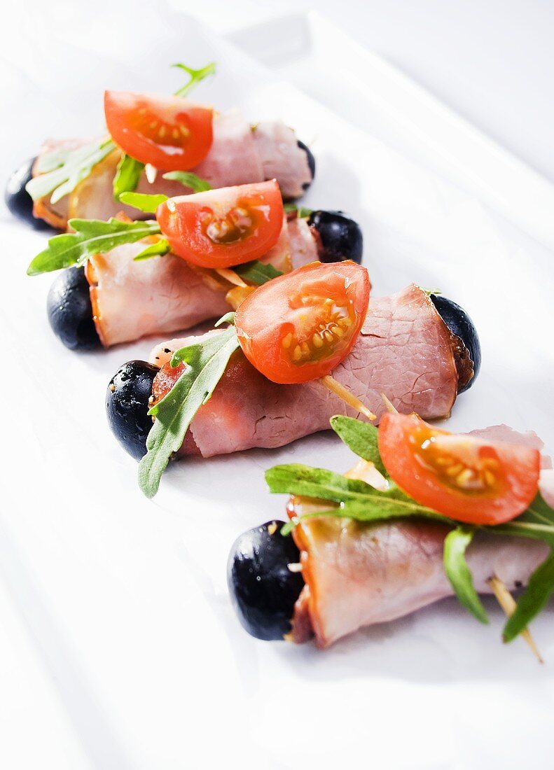 Ham rolls with olives, rocket and tomatoes