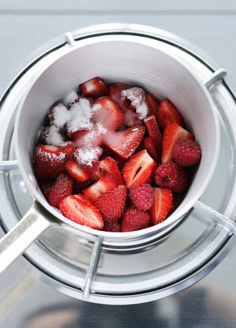 Making berry sauce (sugared berries in pan in bain-marie)