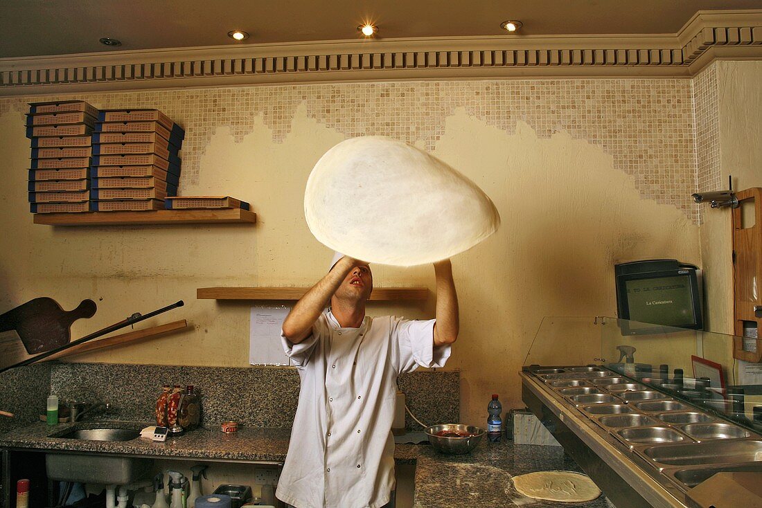 Italienischer Pizzabäcker wirft Teig in die Luft