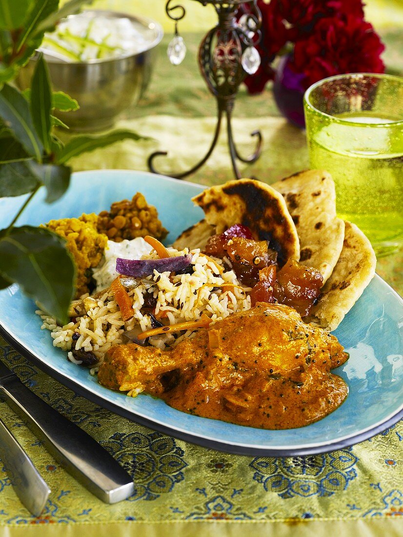 Indian chicken curry with fried rice, lentils, naan bread
